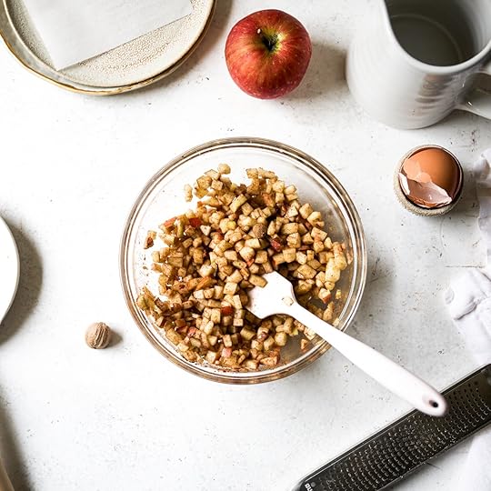 A bowl of finely diced apples tossed with cinnamon and nutmeg, an ingredient mixture for the apple cinnamon scones.