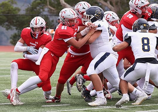 Carmel’s Matthew Maxon looks for running room behind lineman Jack...
