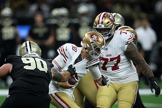 Mac Jones #10 of the San Francisco 49ers is wrapped...