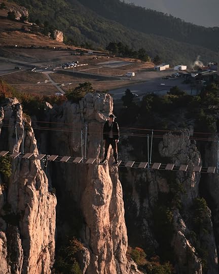 man on rope bridge over canyon