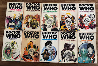 Ten of the first 12 Target novelisations of Doctor Who, cover art by Chris Achilleos and distinctive logo in black