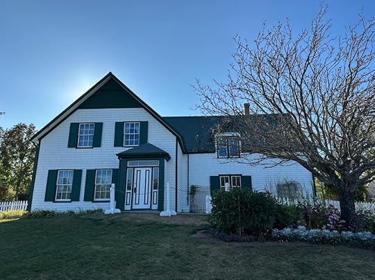 Green Gables: a white farmhouse with green shutters and green trim, and a garden in front
