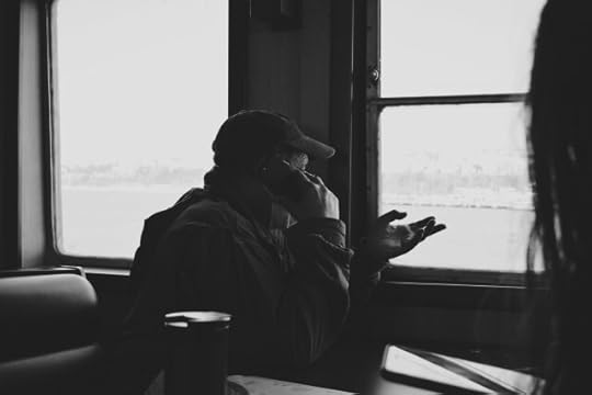 A person on a mobile phone, looking out a window. What will today bring?