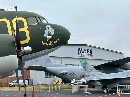 The Douglas C-47 Ruptured Duck has no engines in its nacelles as it stands outside the MAPS Museum at the Akron-Canton Airport in Ohio. Gray skies in the background.