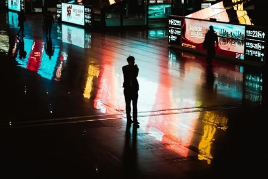 A person in shadow, surrounded by large screens. Why be mindful of all the distractions?