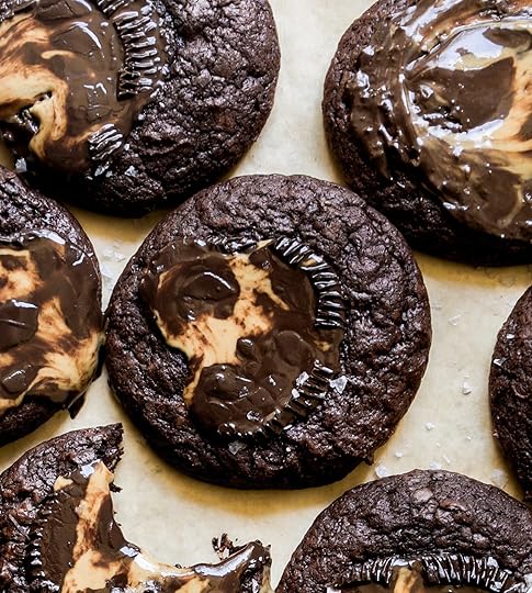 Close-up image of fresh, chewy double chocolate cookies with melted peanut butter cup centers showing a distinct peanut butter and chocolate swirl and crinkled edges.