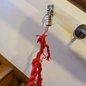 Picture of one of those red ropes they drape across bits where you're not meant to go at events but frayed so badly that only a couple of fibres are left holding the rope onto the hook.