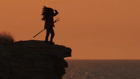 Native American observing from a cliff