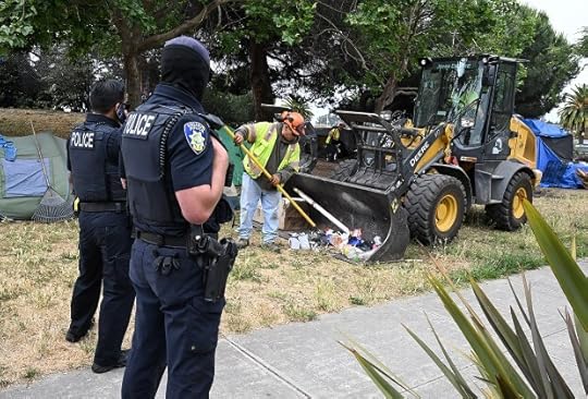 Vallejo Police Officers standby as a city worker rakes trash into a tractor bucket during a cleanup of the encampment area across from the JFK Library on Wednesday. The Vallejo Homeless Union was able to file claims for 90% of the unhoused living in the Georgia Street encampment to prevent the City of Vallejo from clearing tents and temporary homes from the area. (Chris Riley/Times-Herald)