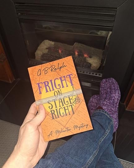 Paperback proof copy of Fright on Stage Right by G. B. Ralph held up with a fireplace in the background.
