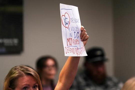 A person lifts a sign as Missouri lawmakers hold a committee hearing to consider redrawing the state's U.S. House districts Thursday, Sept. 4, 2025, in Jefferson City, Mo. (AP Photo/Jeff Roberson)