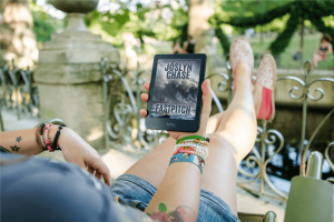 Woman relaxing, reading Fastpitch, by Joslyn Chase