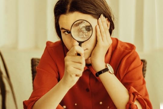 woman looking through magnifying glass