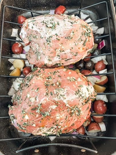 The herb rubbed pork on a roasting rack with the vegetables underneath