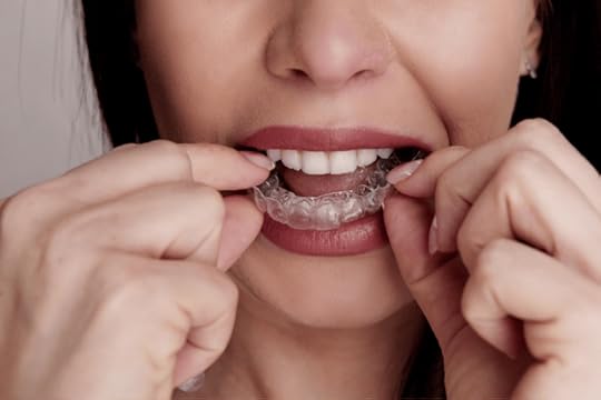 A woman wearing a clear dental night guard.