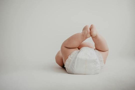 photo of a baby in a diaper laying on their back
