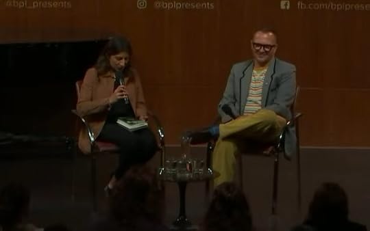 A stage at the Brooklyn Public Library; on it sit Lina Khan and Cory Doctorow, holding mics.