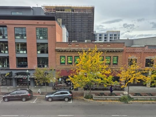 A shot of a few brick buildings across the street from my hotel. Just typical downtown Boise stuff. There's some trees with turning leaves and a couple of parked cars. 
