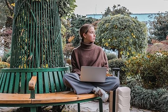 digital nomad working on laptop on bench