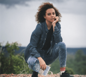 Woman holding a copy of Rapid Pursuit, by Joslyn Chase