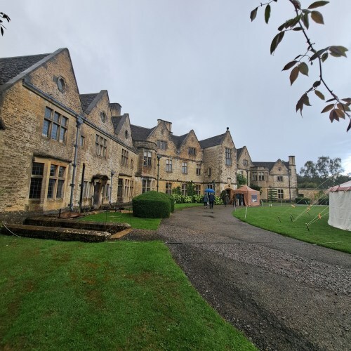 Overcast Rodmarton Manor beneath steely-grey rain clouds 
