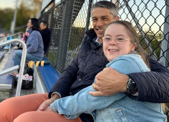 Peter and Penny sit on bleachers keeping each other warm during soccer game