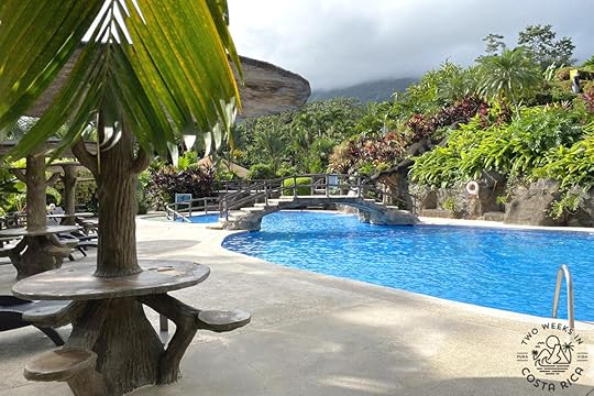 a pool with a bridge and tables