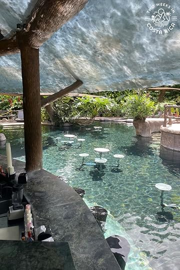 a swim up bar with tables in the water