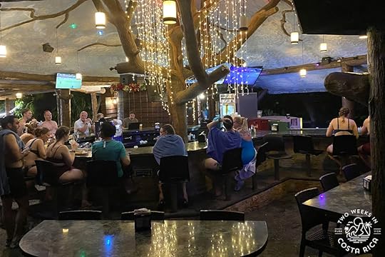 many people at a hot springs bar in arenal at night