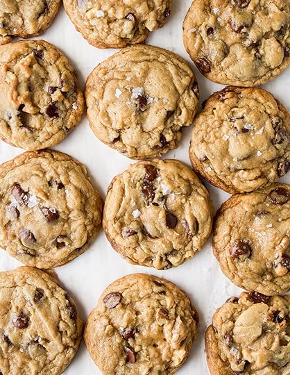 A bunch of cookies with chocolate chips and walnuts sprinkled with flaky sea salt.