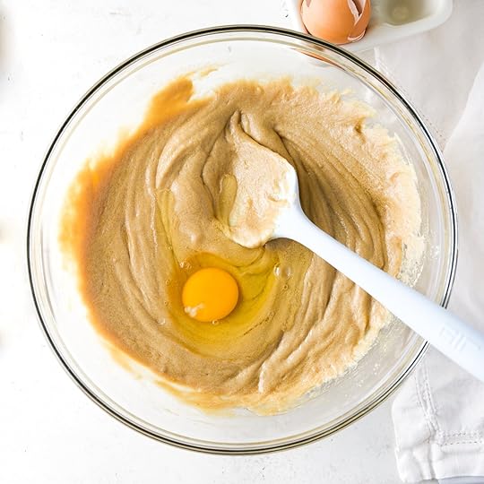 Eggs and sugar and butter all mixed together until creamy in a mixing bowl and spatula.
