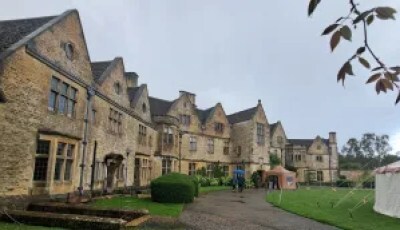 Overcast Rodmarton Manor beneath steely-grey rain clouds