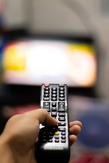 Hand holding a TV remote as a metaphor for directing focus in neuroplasticity and manifestation