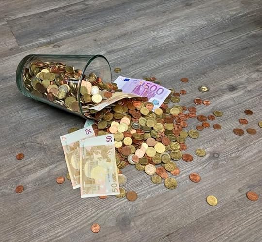 Glass jar spilling coins and euro banknotes onto the floor, symbolizing manifestation quotes for money