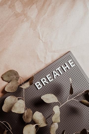 Close-up of the word BREATHE on a textured board with dried leaves