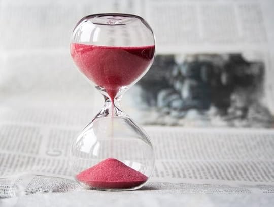 Clear hourglass with red sand symbolizing waiting and the signs your manifestation is not coming