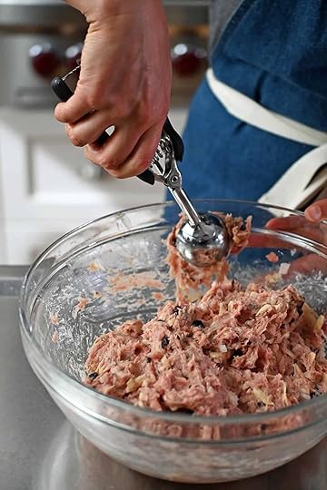 Using a medium ice cream scoop to portion out cranberry turkey meatballs.