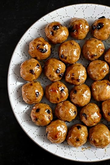 An overhead shot of a white plate topped with cranberry turkey meatballs topped with a gluten free maple Dijon mustard glaze.