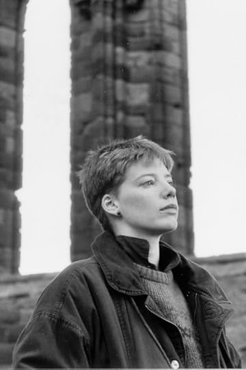 Black and white photo of a young short-haired white woman standing in the ruins of an abbey imagining the past