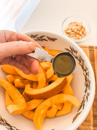 The sliced pumpkin with olive oil being drizzled over it