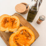 The ingredients for the Oven-Roasted Pumpkin, including the pumpkin cut in half