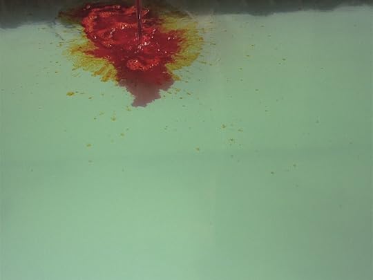 Red dye spills into light green water in 