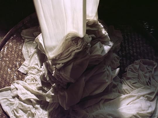 Wet white textiles pour onto a flat woven surface in 