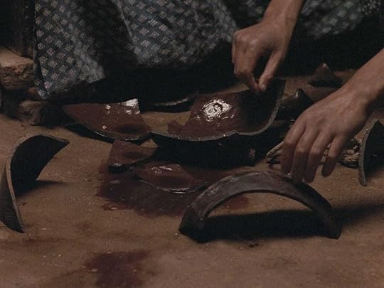 Hands hover over broken brown pottery in 