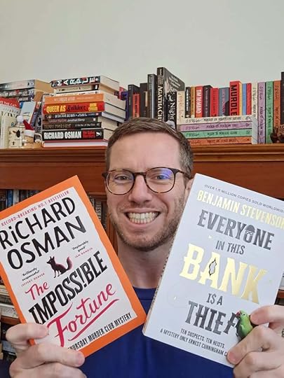 G. B. Ralph selfie holding up two paperback books: The Impossible Fortune by Richard Osman and Everyone in This Bank Is a Thief by Benjamin Stevenson.