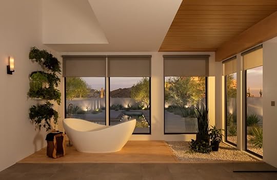 Bathroom with floor to ceiling windows, smart shades and an oval freestanding tub.