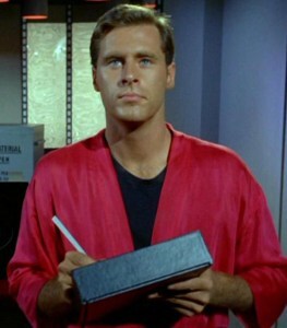 A very blue-eyed transporter technician, writing on one of the TOS-era PADDs and about to get clonked on the head.