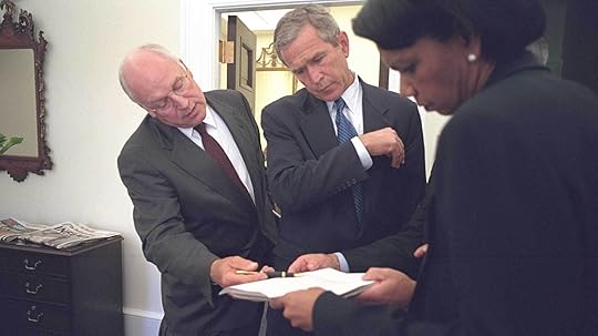 Dick Cheney, George W. Bush and Condoleezza Rice looking over a document.