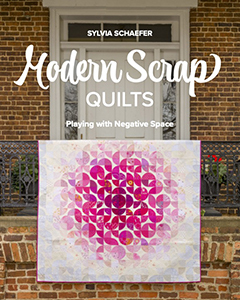A book cover featuring a pink and white quilt draped over a railing. The title is 