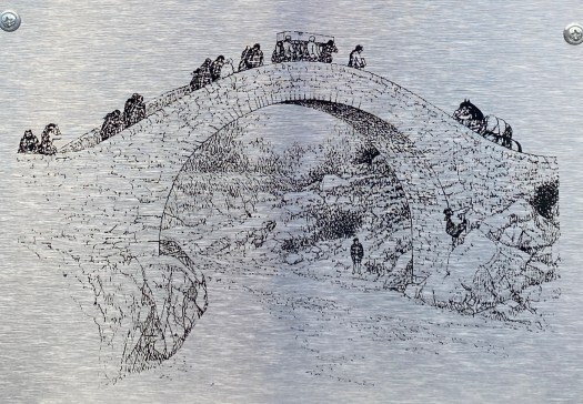 Image of the coffin bridge at Carrbridge, showing how it would have looked in the past with sides: horses and people crossing